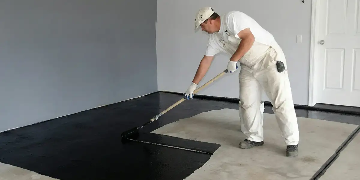 basement waterproofing professional applying waterproof coating to protect a basement floor in Bradenton, FL